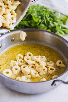 two pans filled with pasta and sauce on top of a table