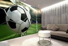 a living room with a couch and soccer ball on the wall in front of it