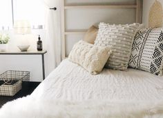 a white bed topped with lots of pillows