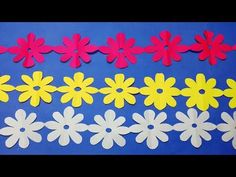 paper flowers are cut out and placed on a blue background with a circle in the middle