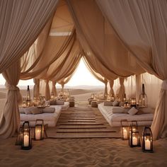 an outdoor desert wedding setup with candles and drapes on the sand, overlooking the desert