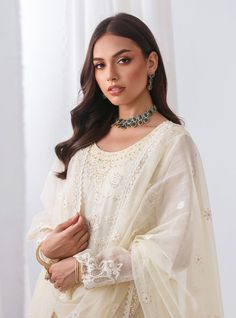 A delicate white silhouette enhanced by floral daaman, intricately embroidered jaal, and laced trims, paired with straight-leg pants and a white net dupatta embellished with lace on all sides making it timeless charm and impeccable craftsmanship. Embrace sophistication and grace with this enchanting ensemble, designed to make you feel effortlessly beautiful on any occasion. Shirt: NetPants: Raw SilkDupatta: Net White Organza Salwar Kameez With Lace Work, White Organza Lawn Suit With Lace Work, White Anarkali Lawn Suit With Sheer Dupatta, Elegant White Lace Salwar Kameez, White Organza Sets With Lace Work, Festive White Lawn Suit With Sheer Dupatta, White Chanderi Anarkali Set With Lace Work, Eid Lace Salwar Kameez With Sheer Dupatta, White Organza Palazzo Set With Chikankari Embroidery