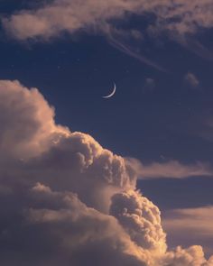 the moon is in the sky above some clouds