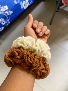 a person holding onto some kind of crochet wrist warmer in their left hand