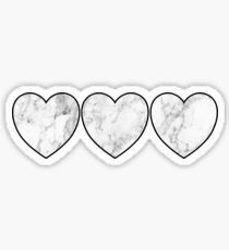 three heart shaped stickers on a white background