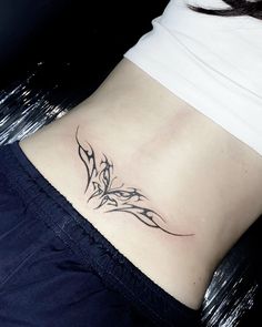 a woman's stomach with a tattoo design on the lower part of her body