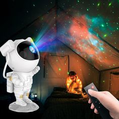 an astronaut is sitting on the bed in front of some colorful lights