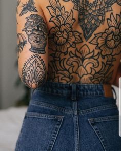 a woman with tattoos on her back holding a cell phone