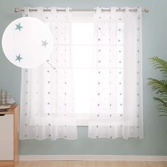 a white curtain with stars on it in front of a window