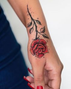 a woman's hand with a rose tattoo on the left side of her arm