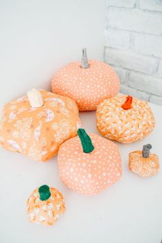 decorative pumpkins are sitting on a white surface next to some other small pumpkins