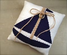 a pillow with a sailboat design on it is tied up and ready to be hung