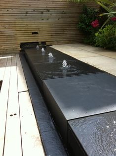 the water is running down the side of the bench in the back yard and into the pool