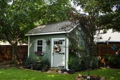 a small shed with flowers on the door