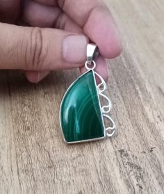 This beautiful pendant features a natural green malachite stone in a fancy shape, set in 925 sterling silver. The charm style locket is handmade with a bezel setting, and is perfect for any occasion including engagement, Christmas, anniversary, Father's Day, birthday, or christening. The pendant has a unique antique and vintage look, with eye clean gemstone clarity grade and a natural creation of the main stone. It is a perfect gift for anyone who loves beauty and African culture. The pendant comes from India and is a one-of-a-kind piece. Gemstone :- Natural Green Malachite  Pendent Weight :- 15.58 Gram  Stone Shape :- Fancy Shape  Metal & Metal Purity :- 925 Solid Sterling Silver We accept custom and personalized order. It can be change in the gemstone, pendant design and pendant size. Pl Green Malachite Cabochon Jewelry, Green Sterling Silver Pendant Jewelry, Green Polished Sterling Silver Gemstones, Green Sterling Silver Gemstones With Polished Finish, Green Spiritual Jewelry With Polished Finish, Green Malachite Gemstone Jewelry, Hallmarked Green Pendant Gemstones, Green Polished Gemstones For Gift, Polished Green Gemstones For Gifts