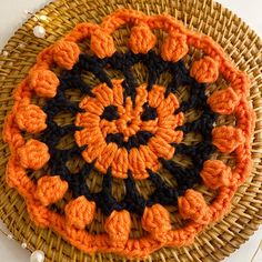 an orange and black crochet design on a wicker basket