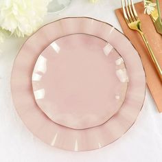 a pink plate sitting on top of a table next to a knife, fork and spoon