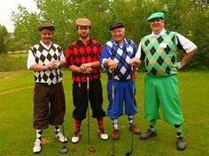 three men in clown costumes standing next to each other on a green grass covered field