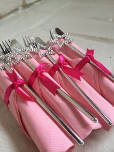 pink napkins and silverware are lined up in a row