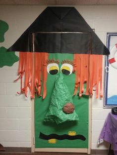 a paper bag that looks like a scarecrow is hanging on the wall in front of a classroom door