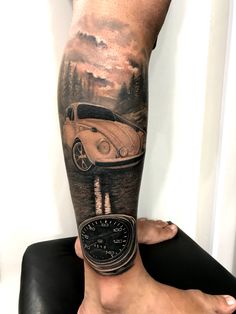 a man's leg with a car on it and a clock in the foreground