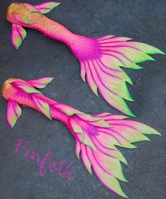 two pink and green fish with the word finfou written on it's side