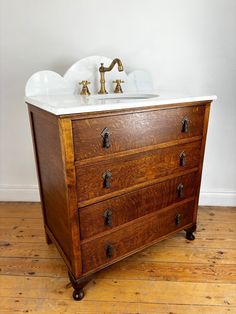 an old dresser with a sink and faucet