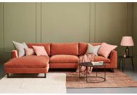 a living room with an orange couch and two lamps on either side of the couch