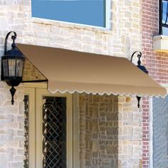 a white awning on the side of a brick building next to a lamp post