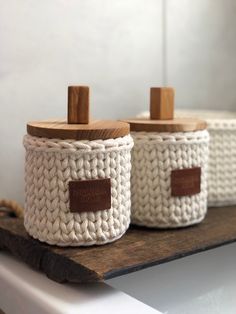 two crocheted baskets sitting on top of a wooden shelf