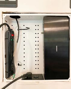 the inside of a white box with wires and other electrical equipment in it's compartment