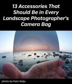 a hand holding up a lens with the words 13 accessories that should be in every landscape photographer's camera bag