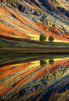 the mountains are reflected in the still water