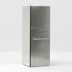 a tall metal refrigerator freezer sitting on top of a white floor