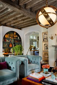 a living room filled with furniture and a fire place under a light hanging from the ceiling