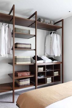 an open closet with clothes hanging on shelves