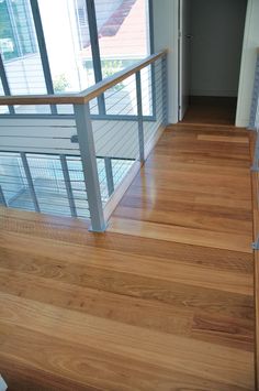 an empty room with hard wood floors and railings on the second floor, looking down