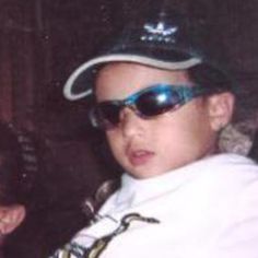 a young boy wearing sunglasses and a hat