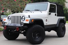 a white jeep parked in front of a house