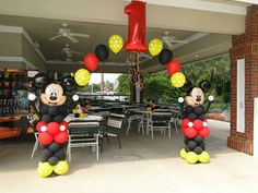 mickey and minnie mouse balloons in the shape of numbers one - two at an outdoor dining area