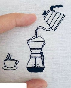 someone is stitching something on to a t - shirt with coffee and a cup