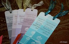 four tags with words on them are sitting on a tablecloth, one is blue and the other is pink