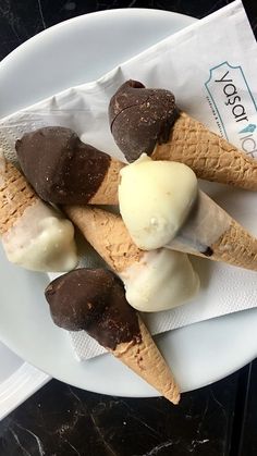 three ice cream cones on a plate with chocolate and vanilla in the middle, sitting on a table