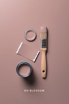 a paintbrush and some other items on a pink surface