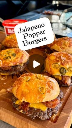 several hamburgers with cheese and other toppings on a cutting board