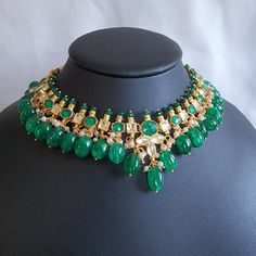 Stunning pachi kundan and natural stone necklace set in forest green and gold. Stones are set in silver foil and 18kt gold plated. Green Temple Jewelry Necklaces With Stones, Green Temple Jewelry Necklace With Stones, Gold Bridal Necklace With Emerald Gemstone, Green Jeweled Emerald Necklace, Gold Emerald Bridal Necklace With Gemstones, Green Emerald Jeweled Necklace, Green Kundan Necklace With Gemstone, Green Kundan Temple Necklace For Party, Festival Kundan Emerald Necklace