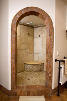 an arched doorway leads into a bathroom with a walk in shower