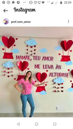 a woman standing in front of a wall with hearts on it and the words mama, tu