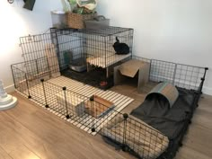 a caged in area with various items on the floor, including a cat bed