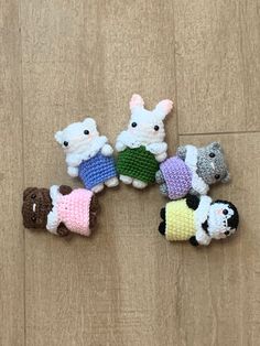 small crocheted animals sitting on top of a wooden floor